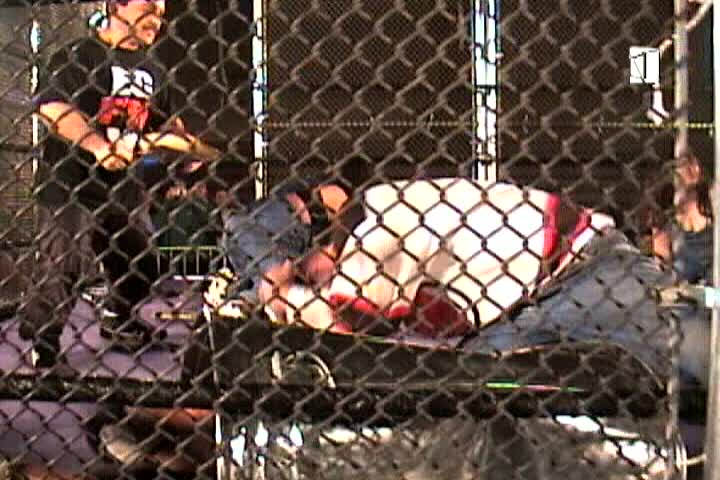 midget wrestlers in steel cage beating up men and strippers