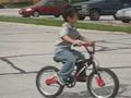 Huey is riding bike without training wheels