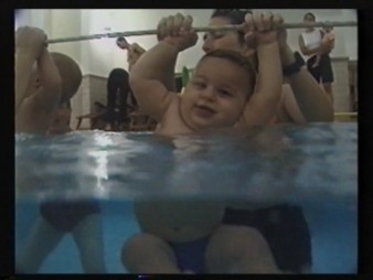 Babies swing on a rope in the pool